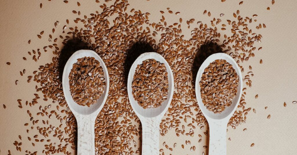 Flat lay of organic flaxseeds in wooden spoons showcasing natural nutrition and texture.
